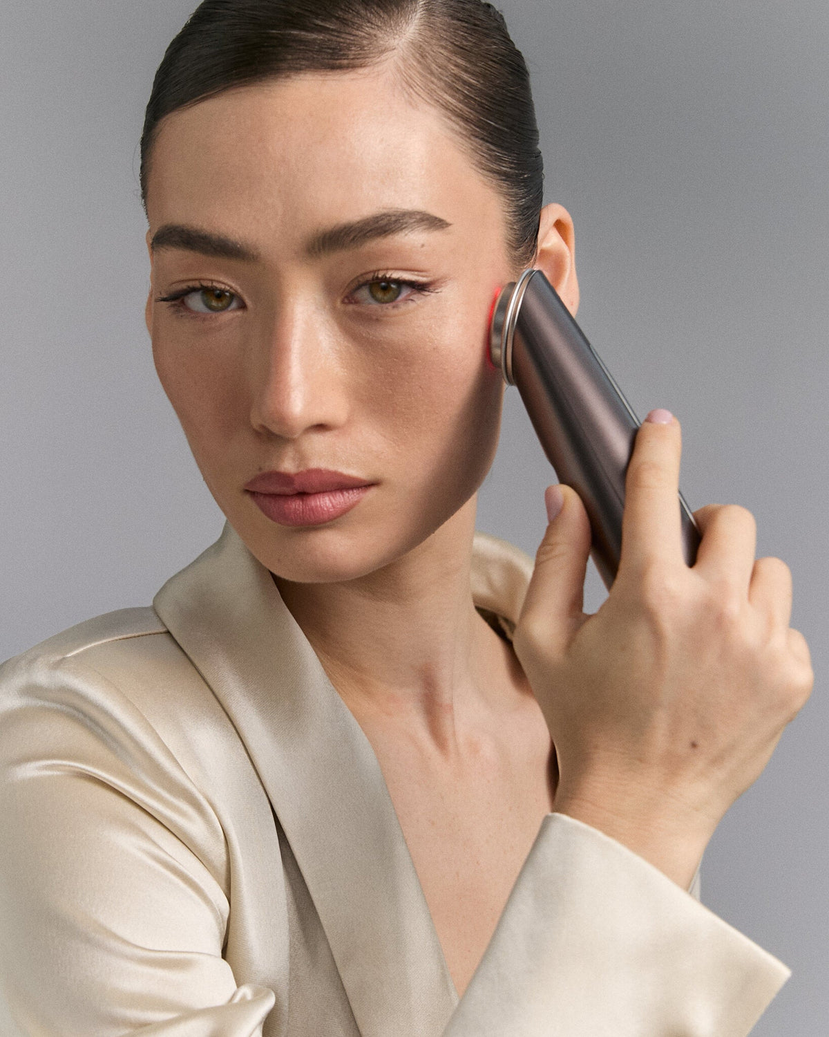 Woman using an RF beauty device on her face
