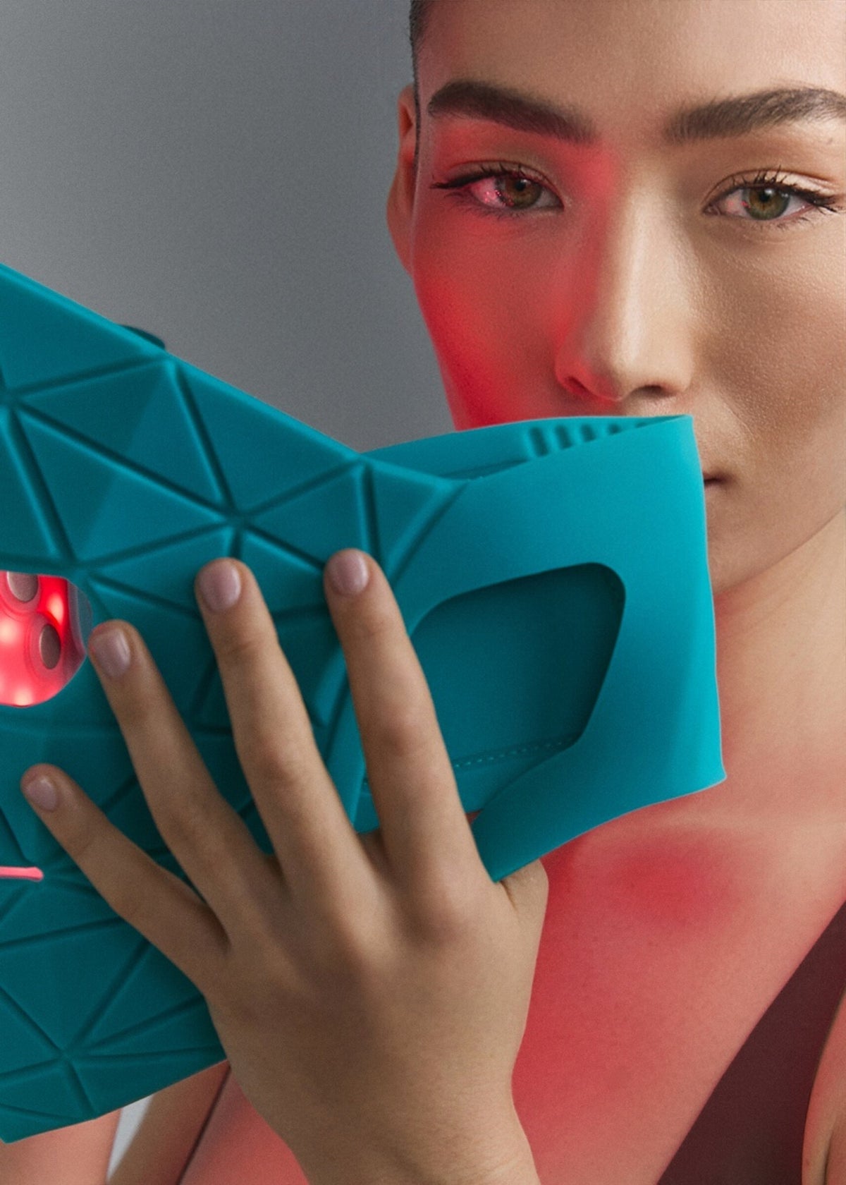 Model holding Blue Green Mask Lift over her face
