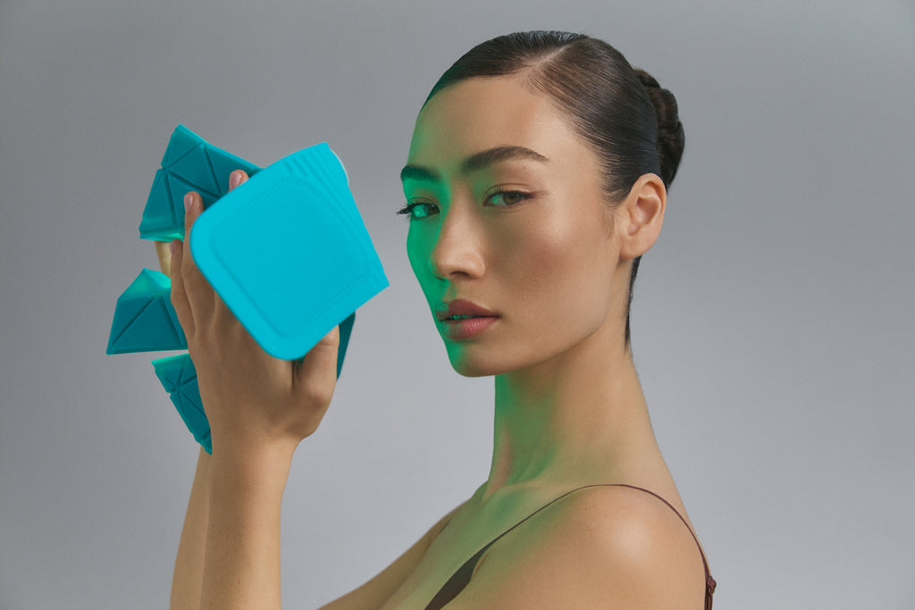 Modella che tiene la Blue Green Mask Lift con luce verde accesa