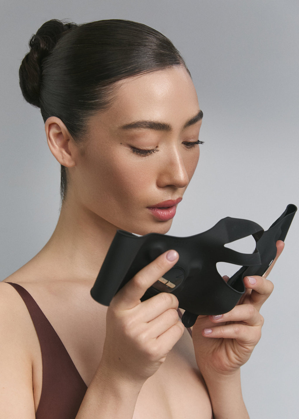 Mannequin tenant le masque EMS Medi Lift Plus à deux mains