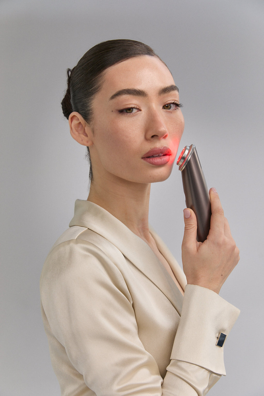 Model holding Photo Plus Deep Lift near her lips, red light on